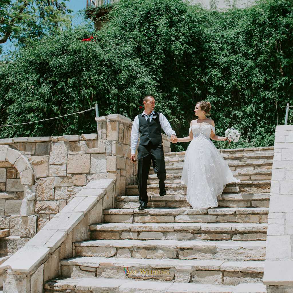 Newlyweds walking down stone steps in the garden