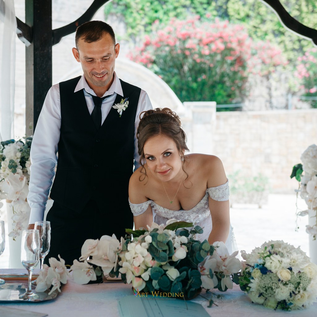 Bride signing documents at the Peyia Gardens ceremony