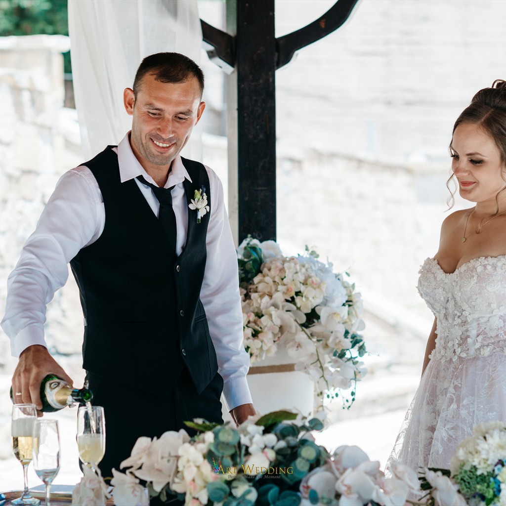 Groom pouring champagne at the wedding table