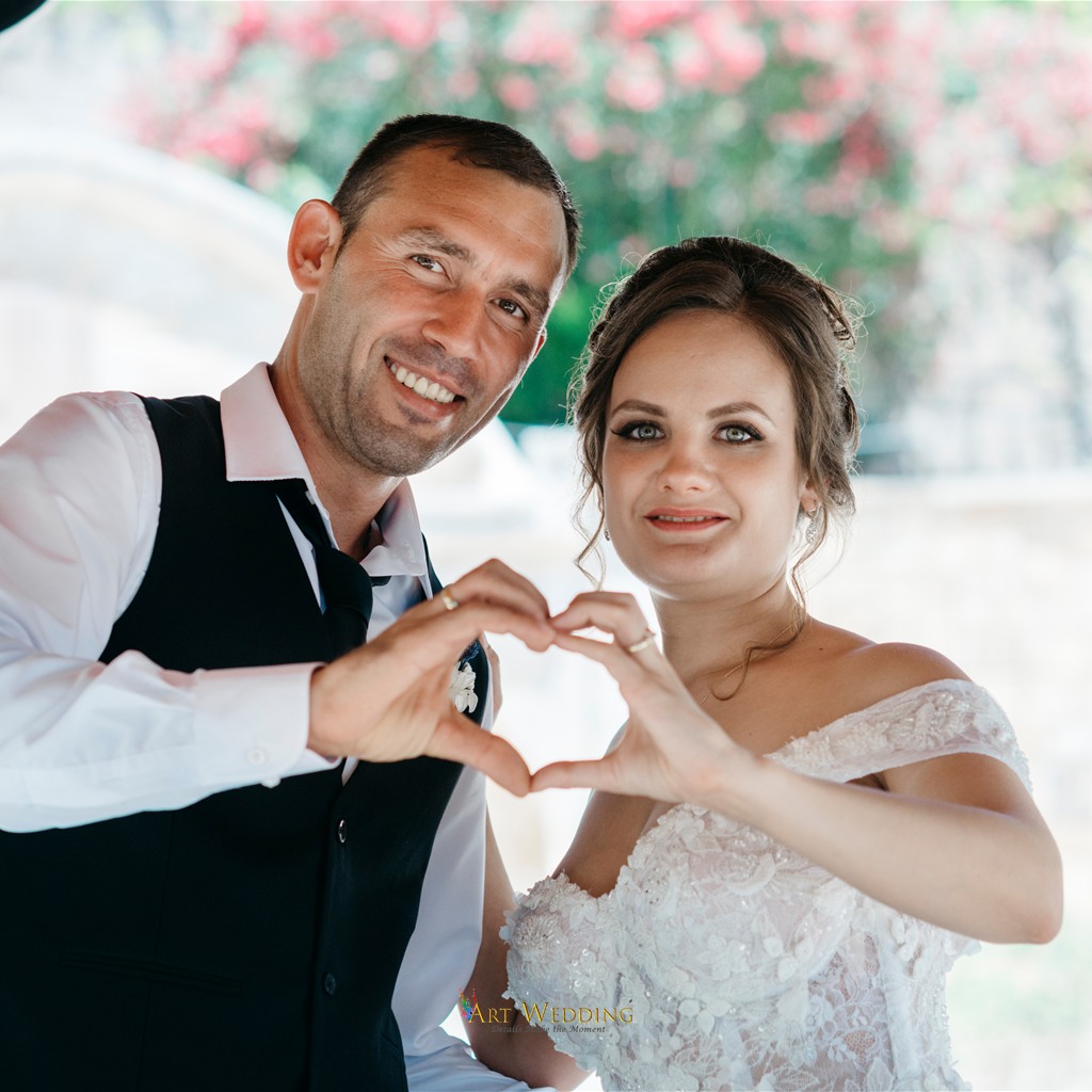 Newlyweds making a heart with their hands in the gazebo