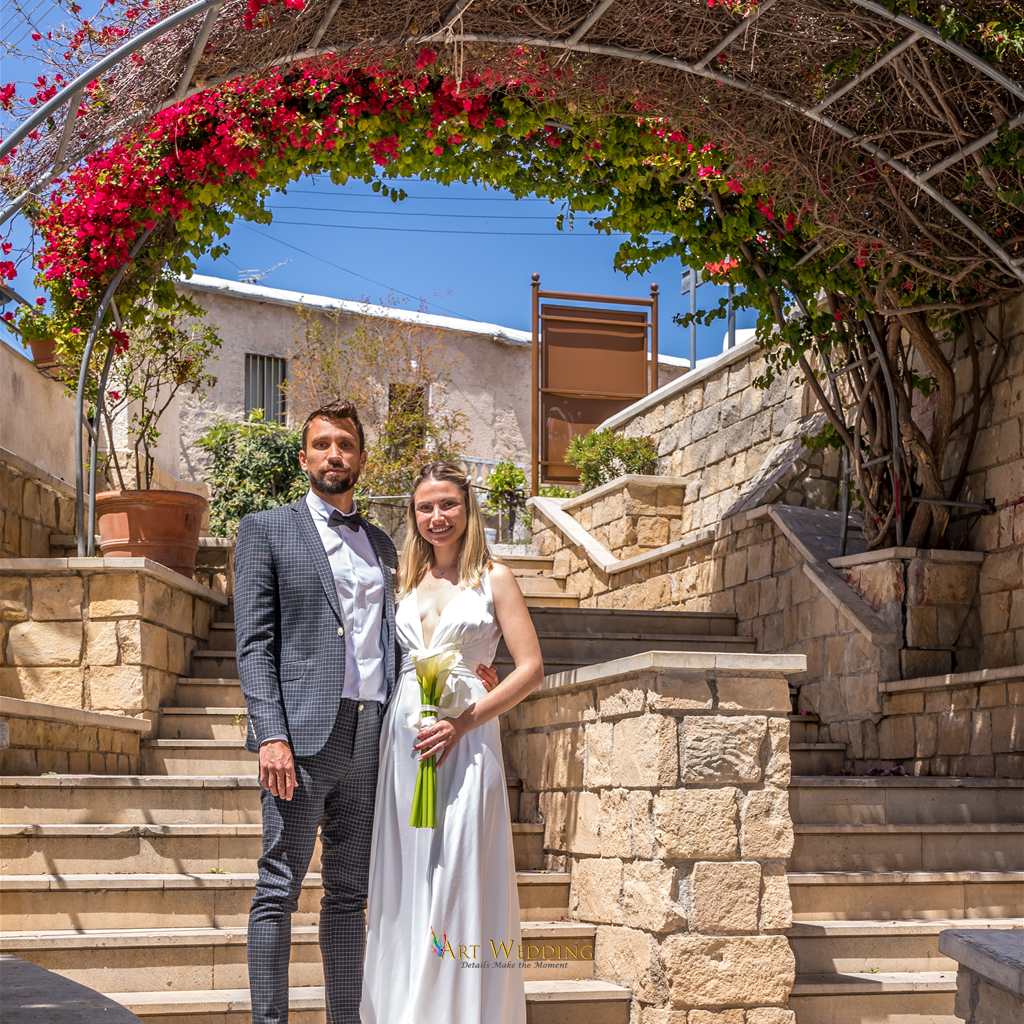 Newlyweds beneath a bougainvillea arch
