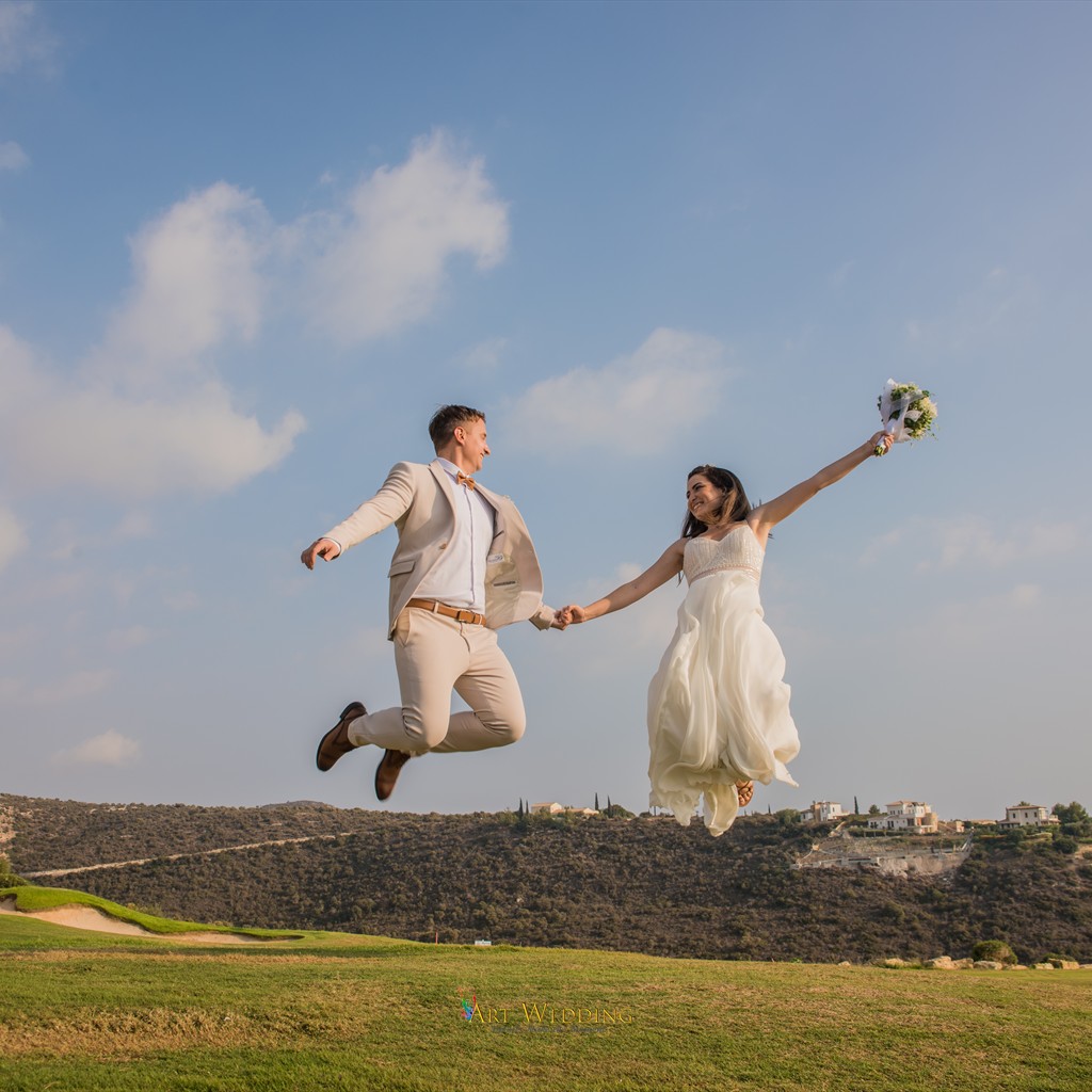 Newlyweds jumping hand in hand during their photo walk