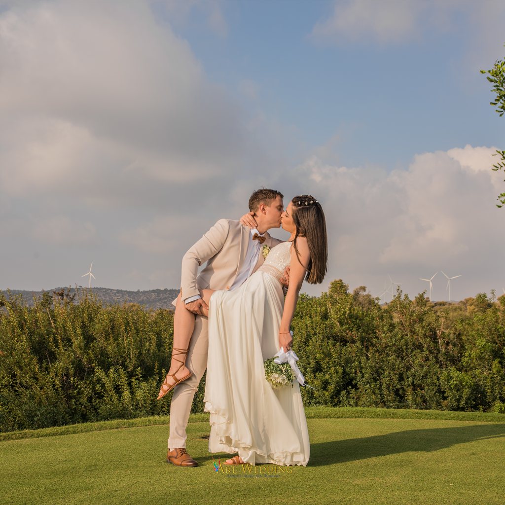 Newlyweds kissing on a green lawn