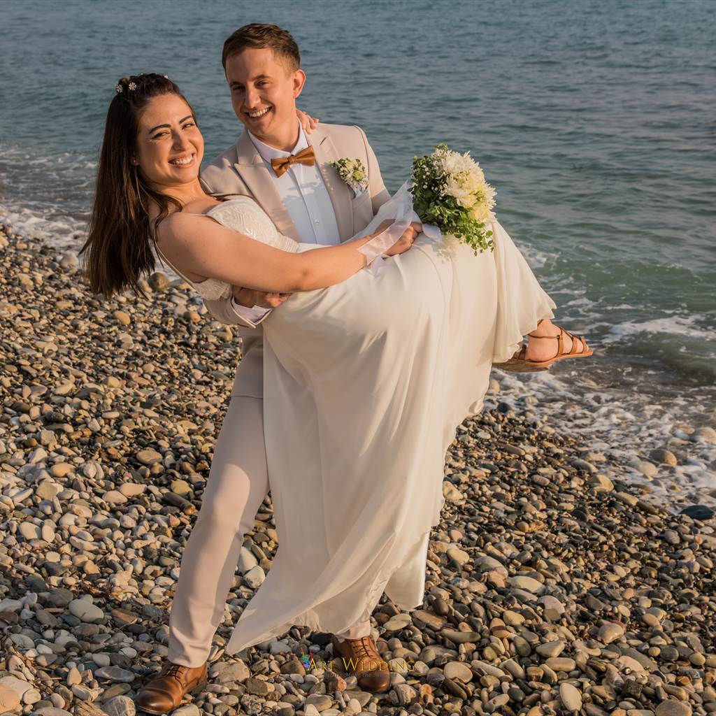 Smiling newlyweds on the pebble beach