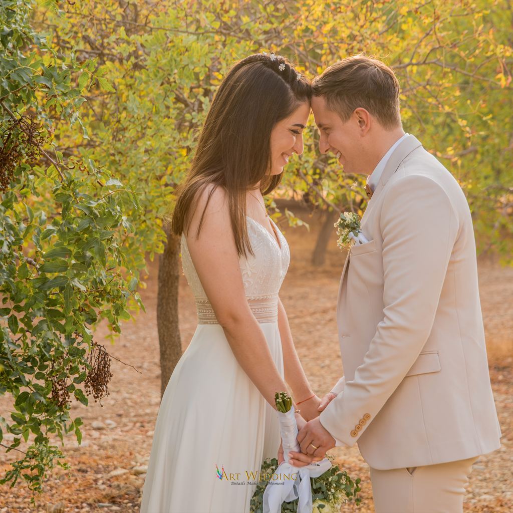 Newlyweds holding hands among green trees