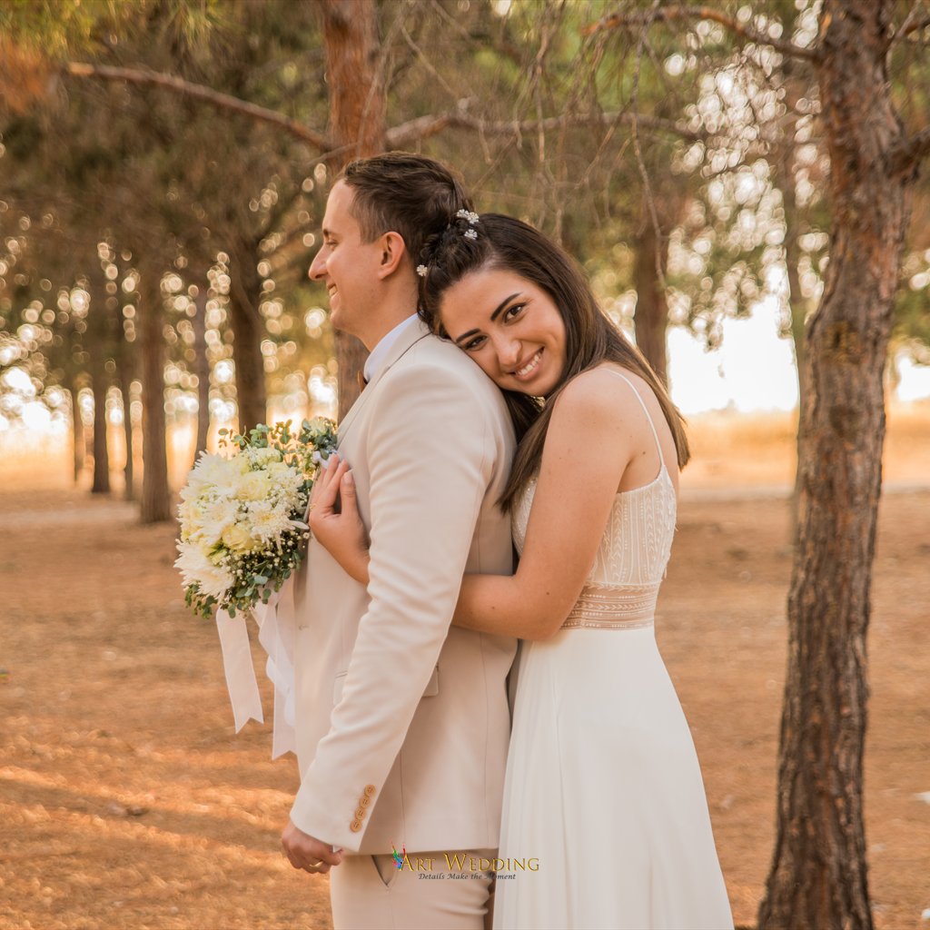 Smiling bride hugging the groom during a woodland photo walk
