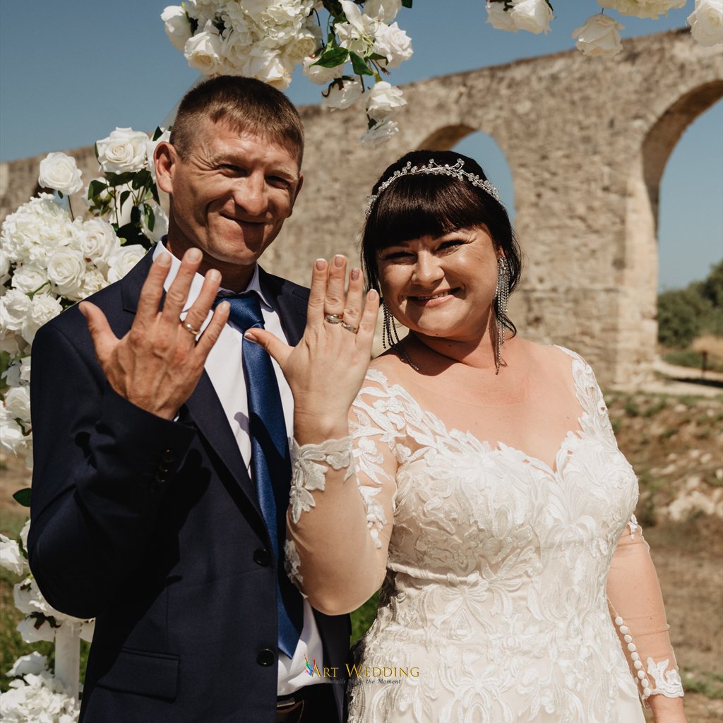 Newlyweds showing their wedding rings at the aqueduct
