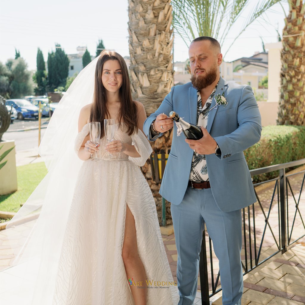Groom opening champagne after the ceremony