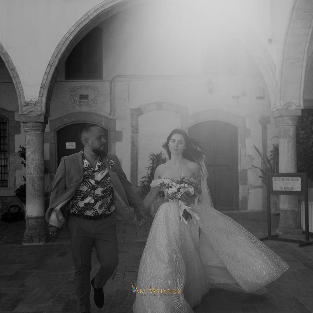Black and white wedding walk beneath Larnaca arches