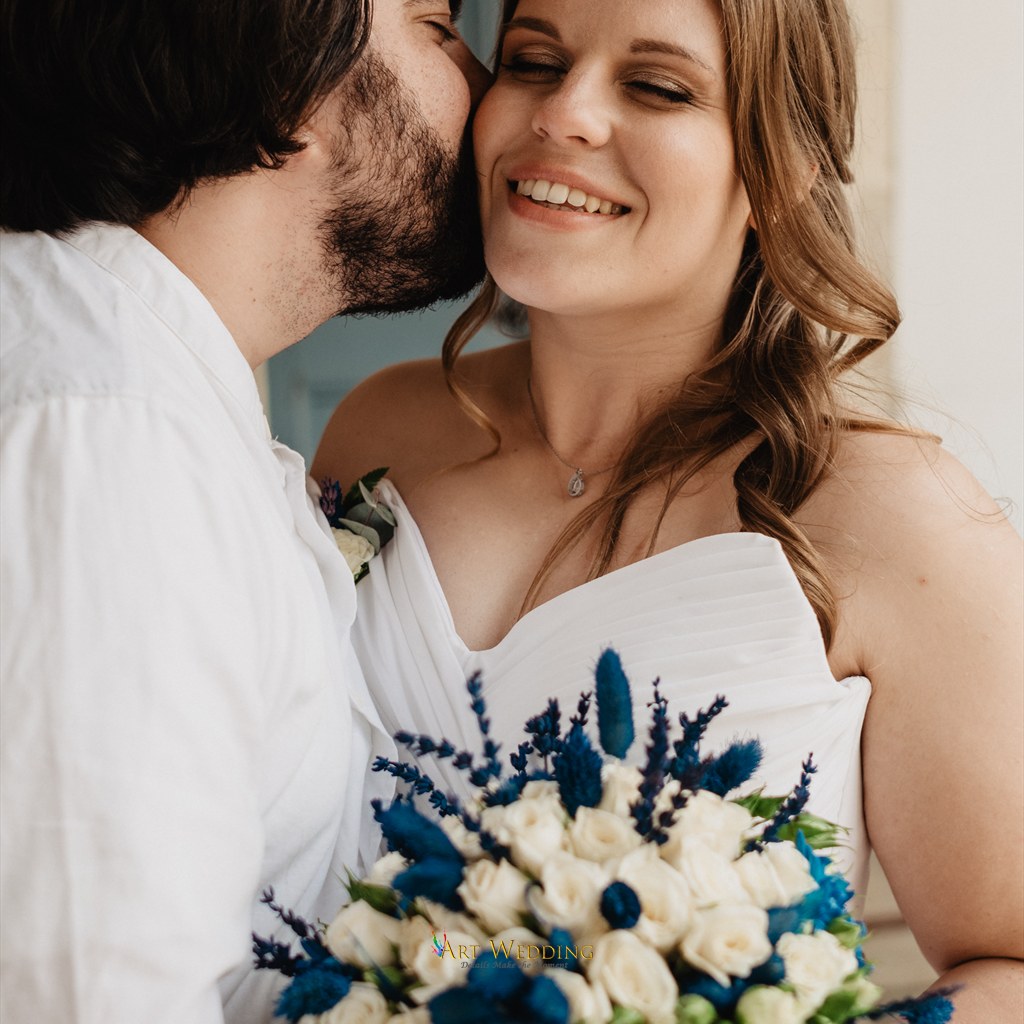 Groom kissing his smiling bride on the cheek