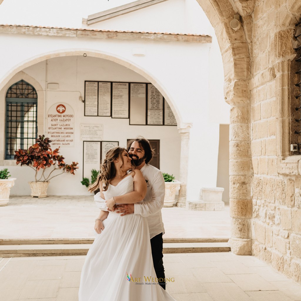 Newlyweds embracing beneath stone arches in Larnaca