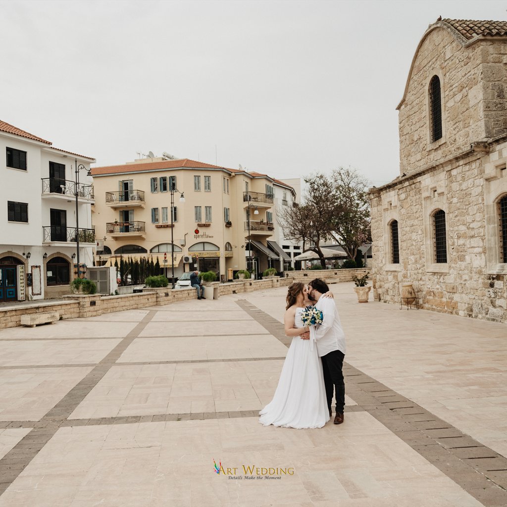 Newlyweds kissing in a Larnaca square