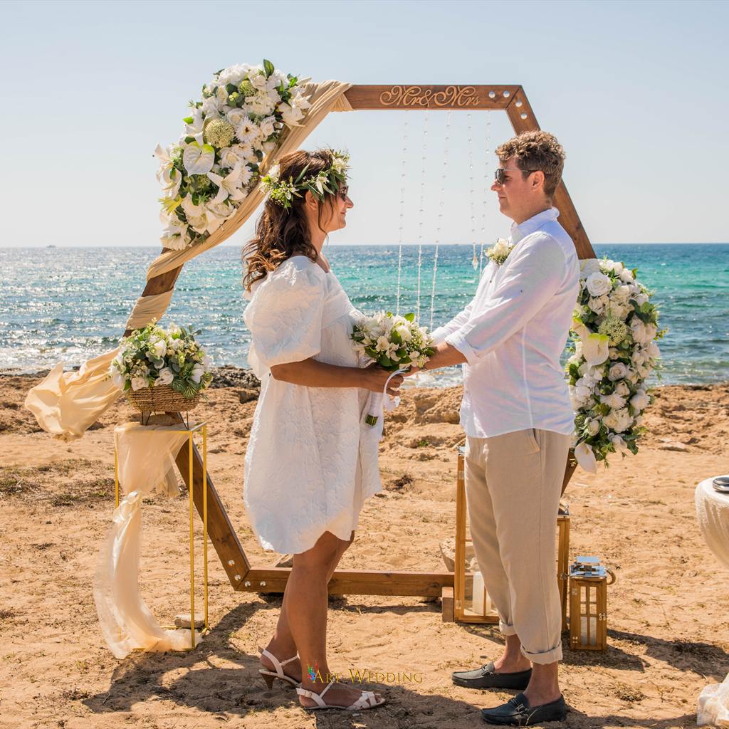 החתן והכלה מחזיקים ידיים במהלך הטקס