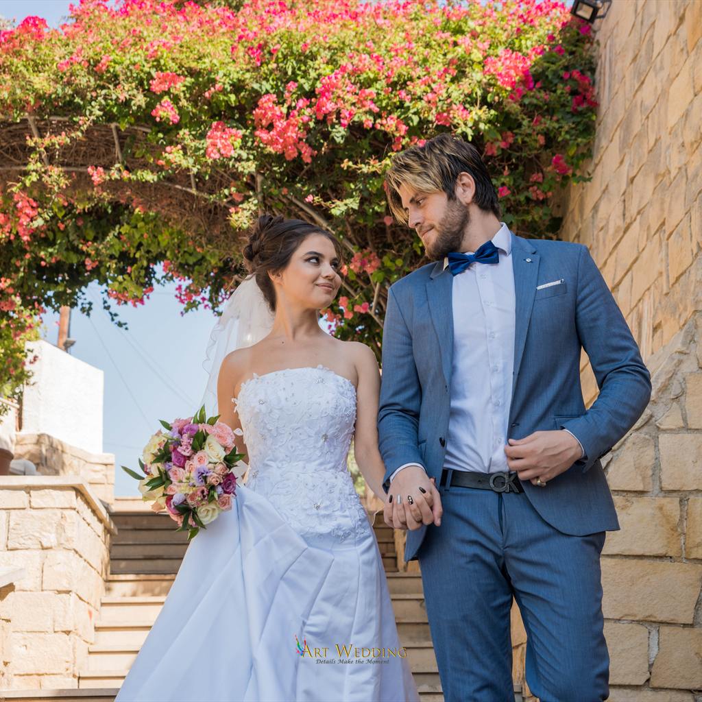 Wedding at Aphrodite Gardens — couple beneath a flowering arch