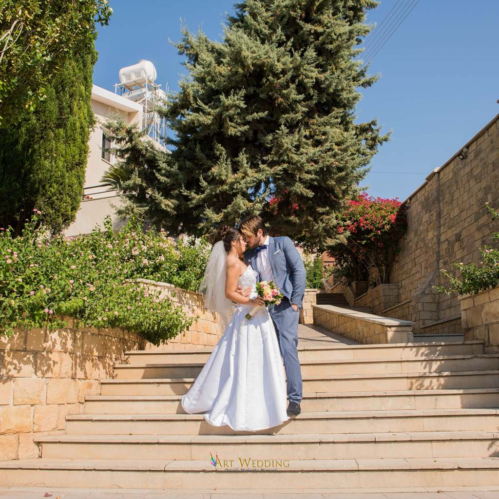 Newlyweds kissing on the garden steps