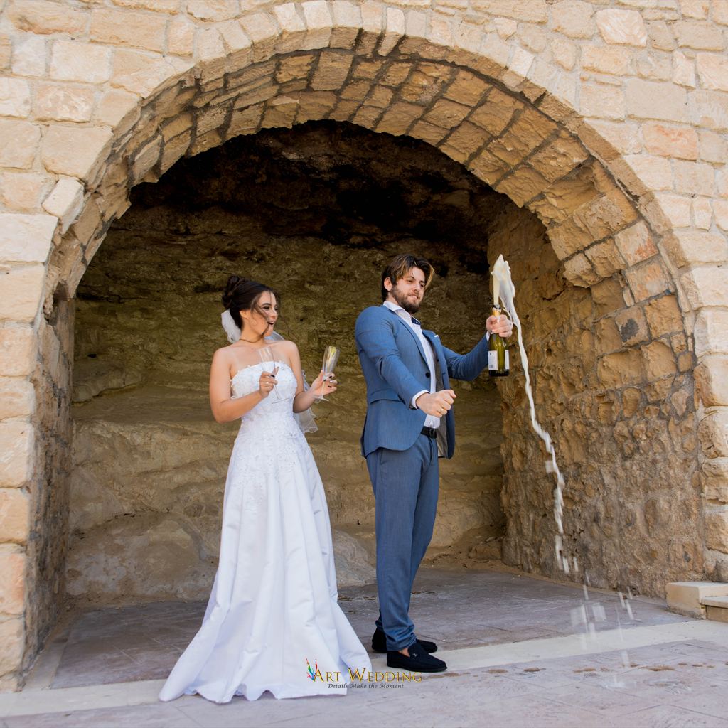 Groom opening champagne after the ceremony