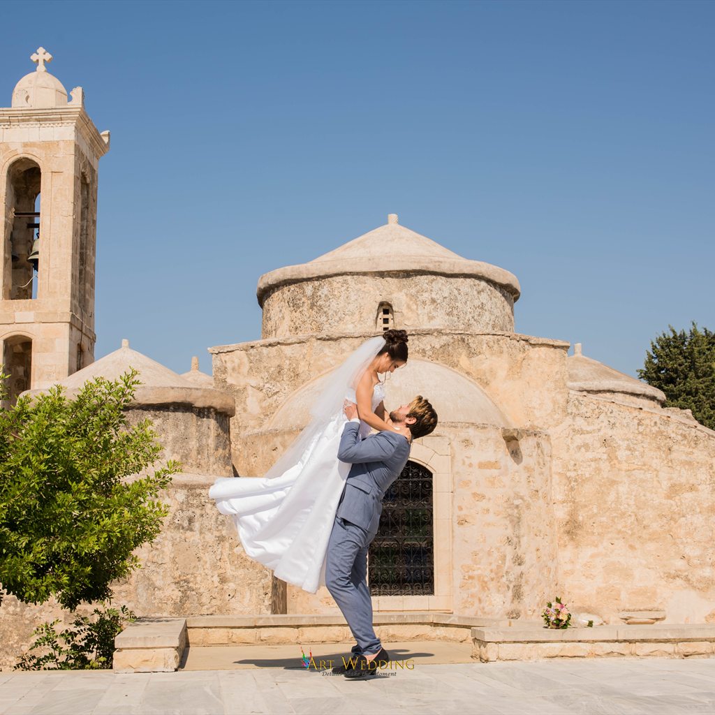 Wedding portrait of a couple by an old church