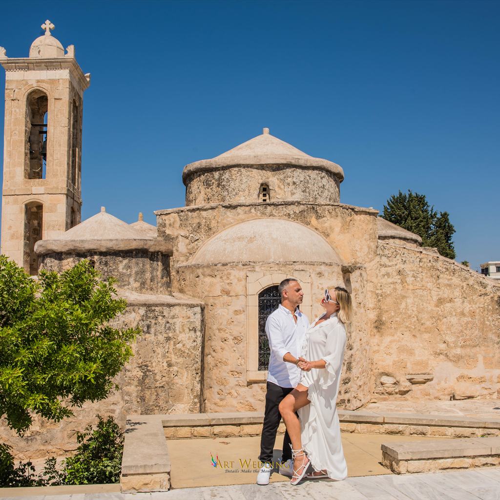 Newlyweds holding hands by an old church