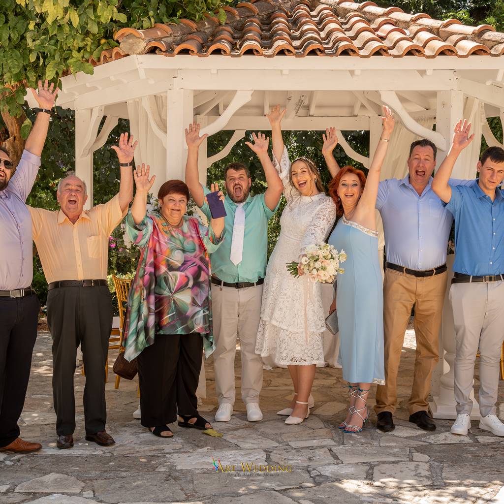 Newlyweds and guests celebrating in the Peyia Gardens gazebo