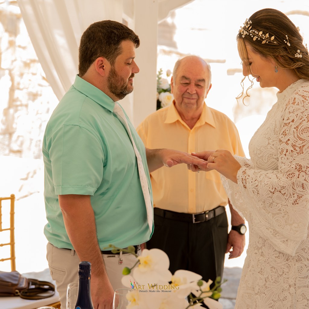 Bride placing a ring on the groom’s finger