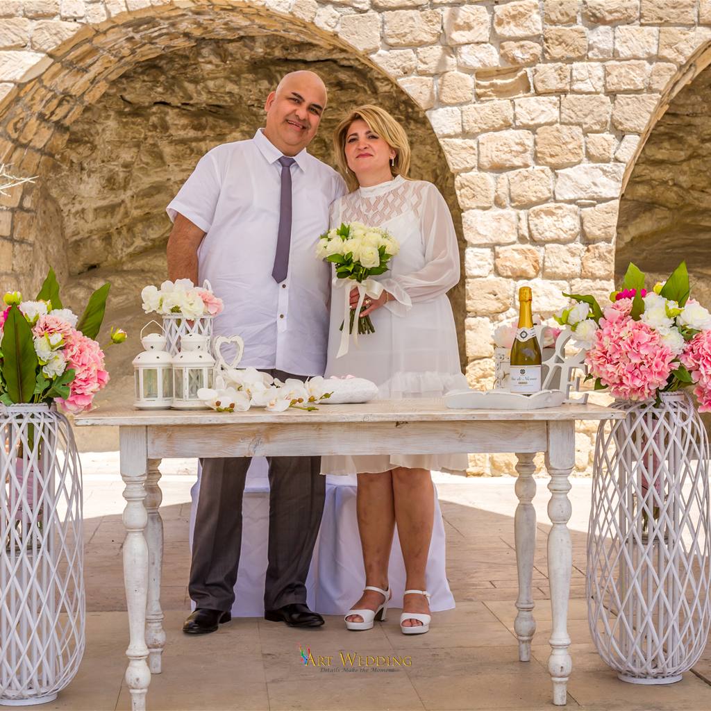 Newlyweds by a ceremony table with floral decorations