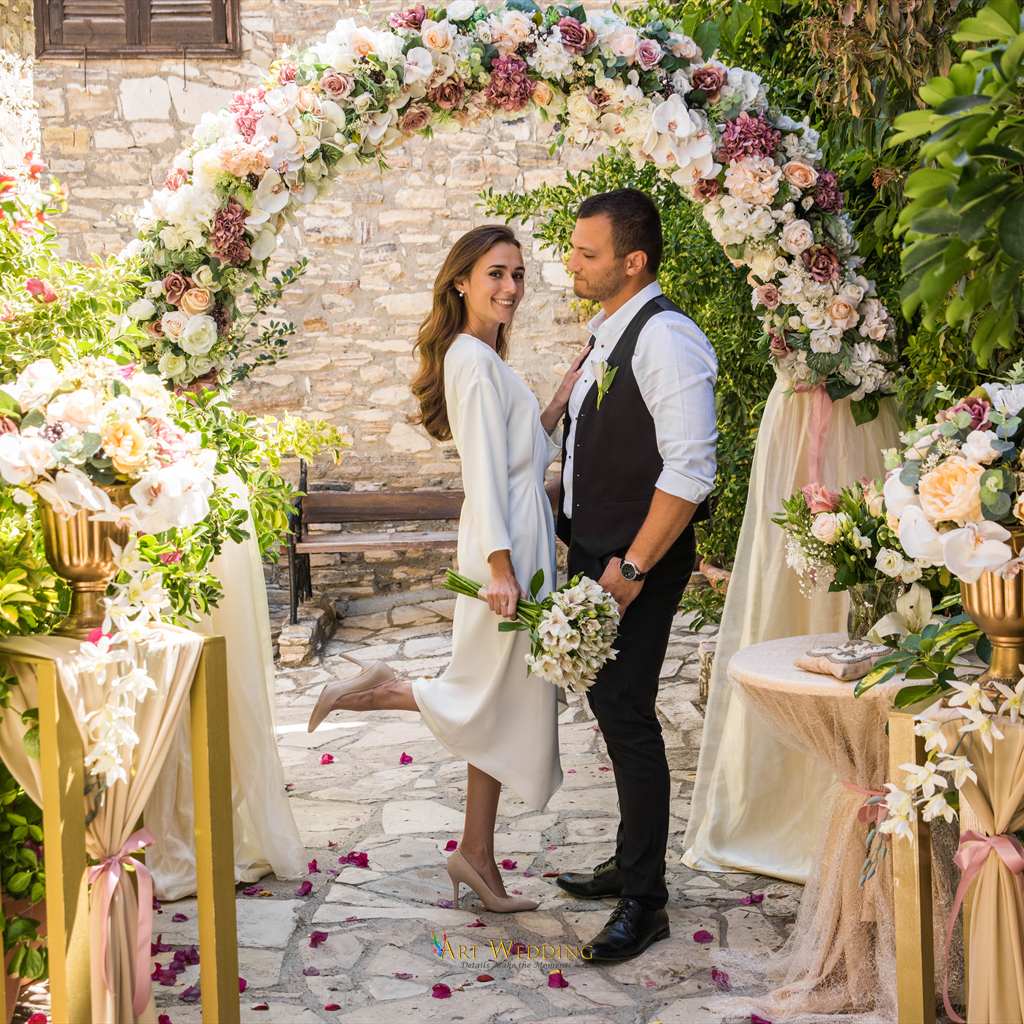 Wedding portrait beneath a floral arch — Lefkara, Cyprus