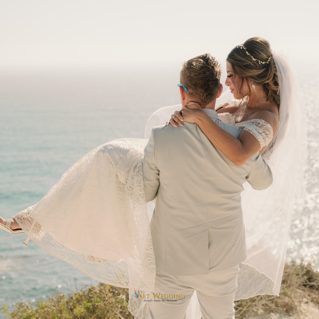 Groom lifting the bride against the white cliffs