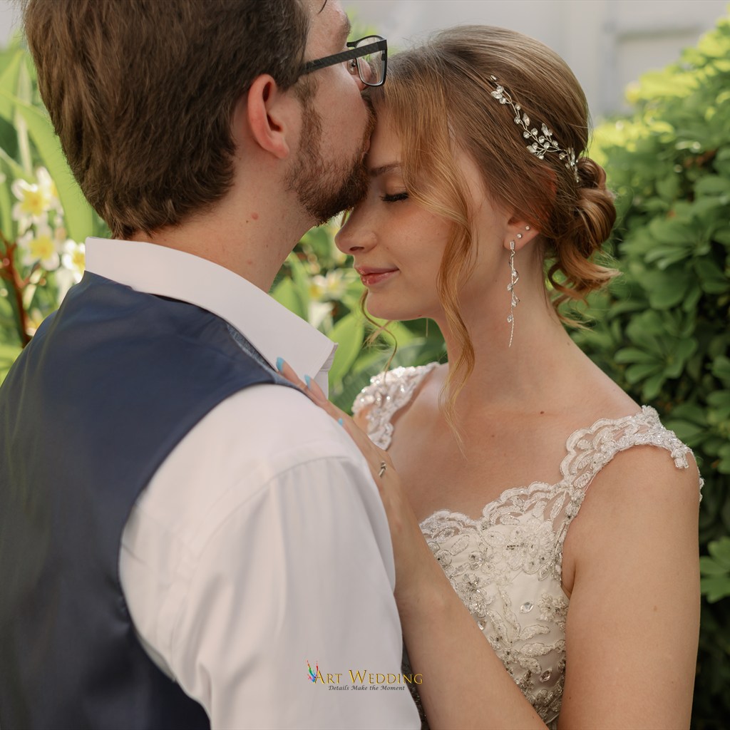 A tender kiss on the forehead during a wedding photo walk