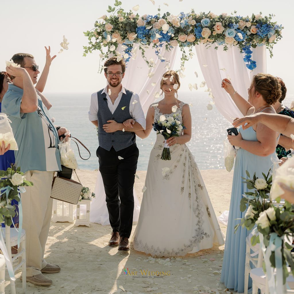 Newlyweds walking through flower petals