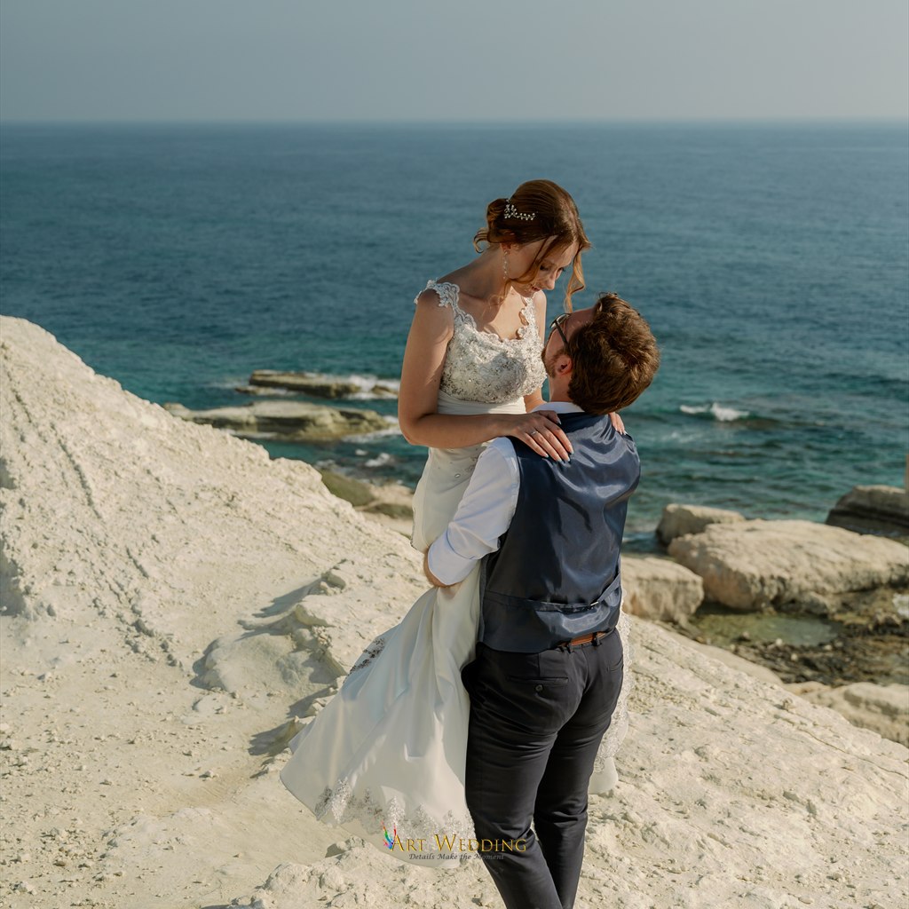 Groom lifting the bride against the white cliffs