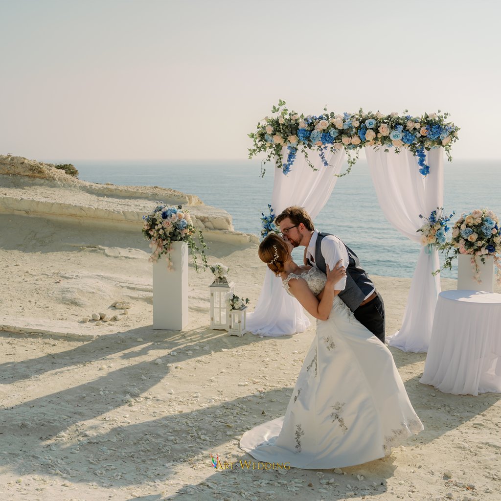 Newlyweds kissing in front of the floral arch
