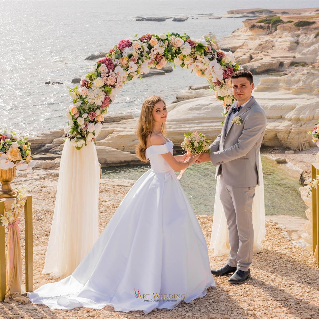 Couple beneath a floral arch at the White Cliffs of Peyia