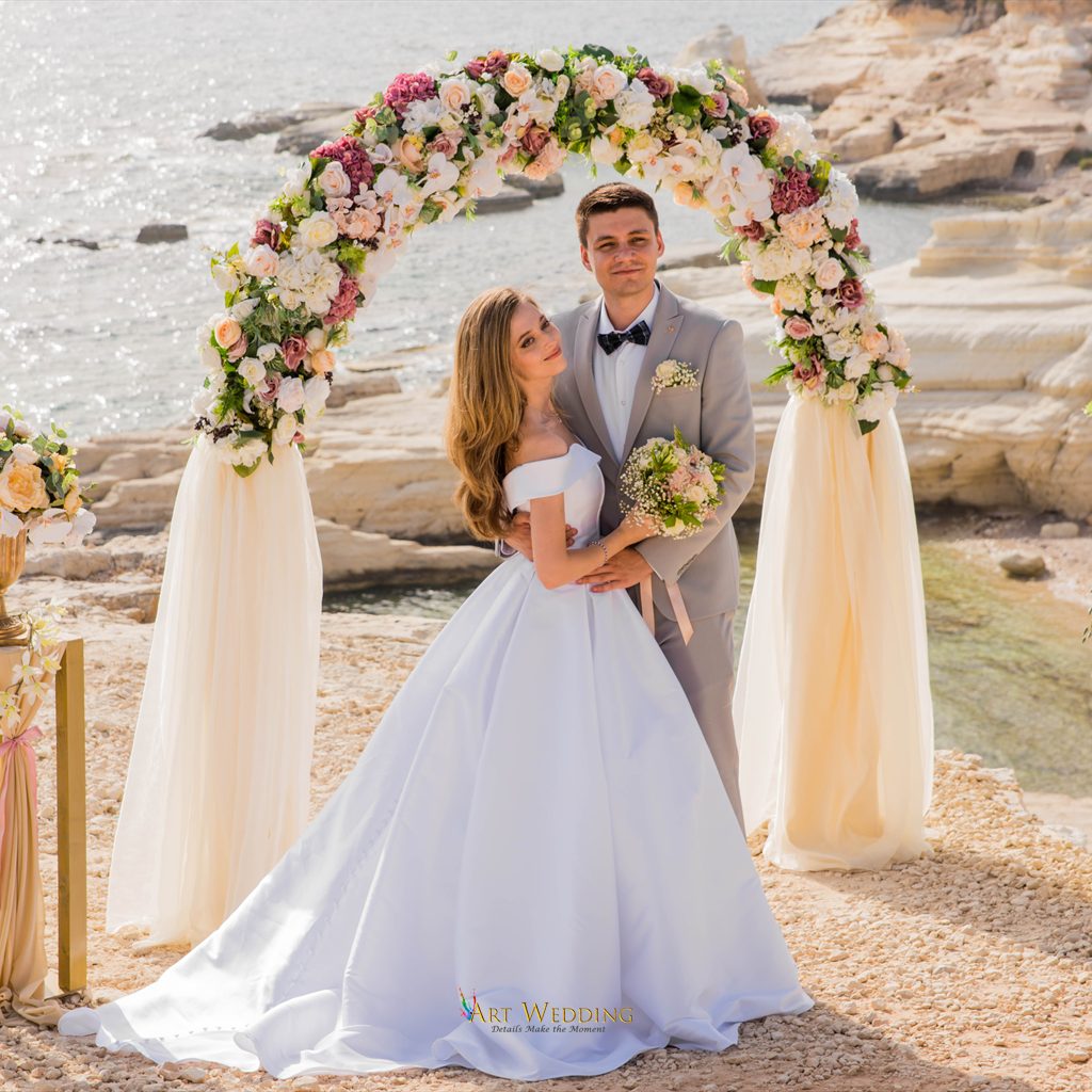 Couple beneath a floral arch at the White Cliffs of Peyia