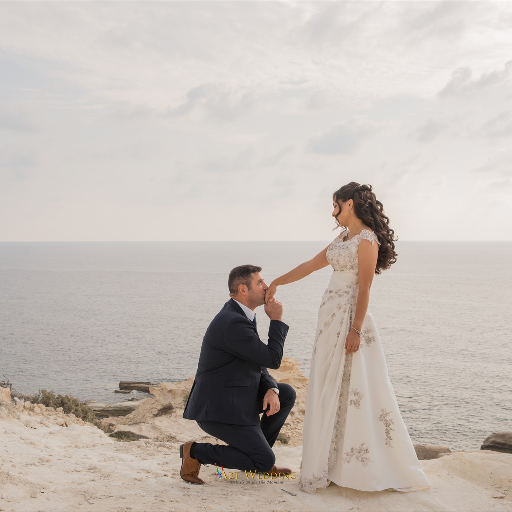 Groom kissing the bride’s hand on the white cliffs