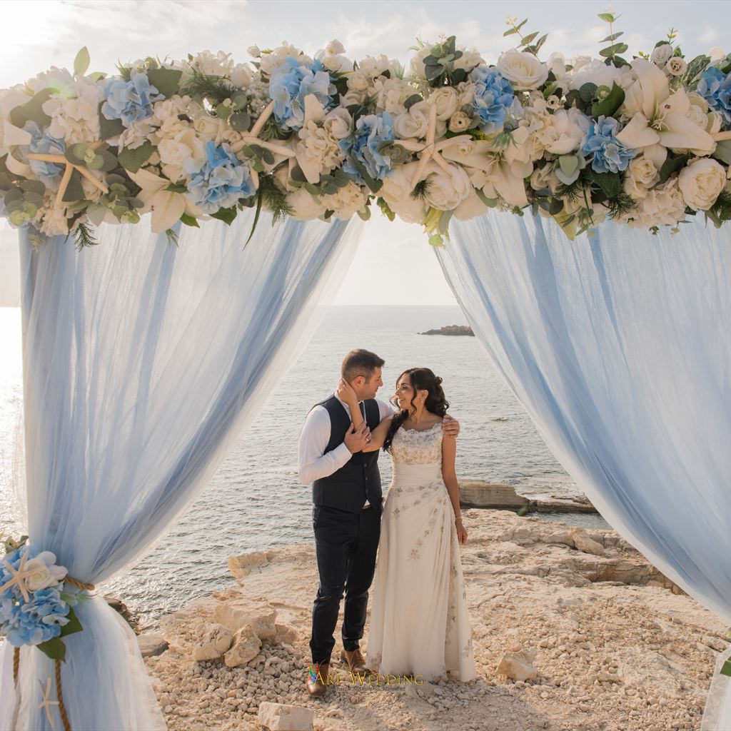 Couple beneath a floral arch at the White Cliffs of Peyia