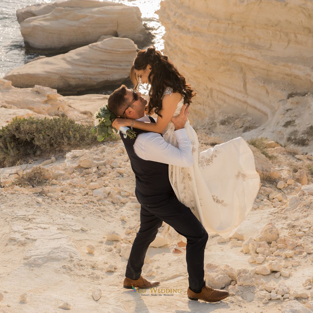 Groom lifting the bride against the white cliffs