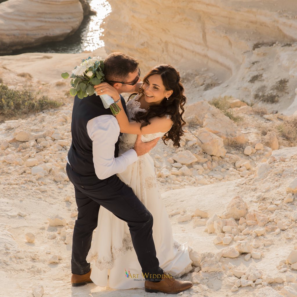 Tender wedding portrait on white rocks by the sea