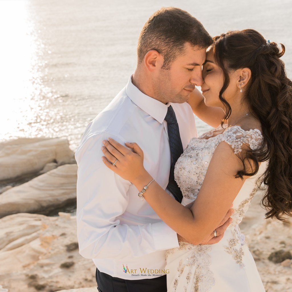 Tender wedding portrait on white rocks by the sea