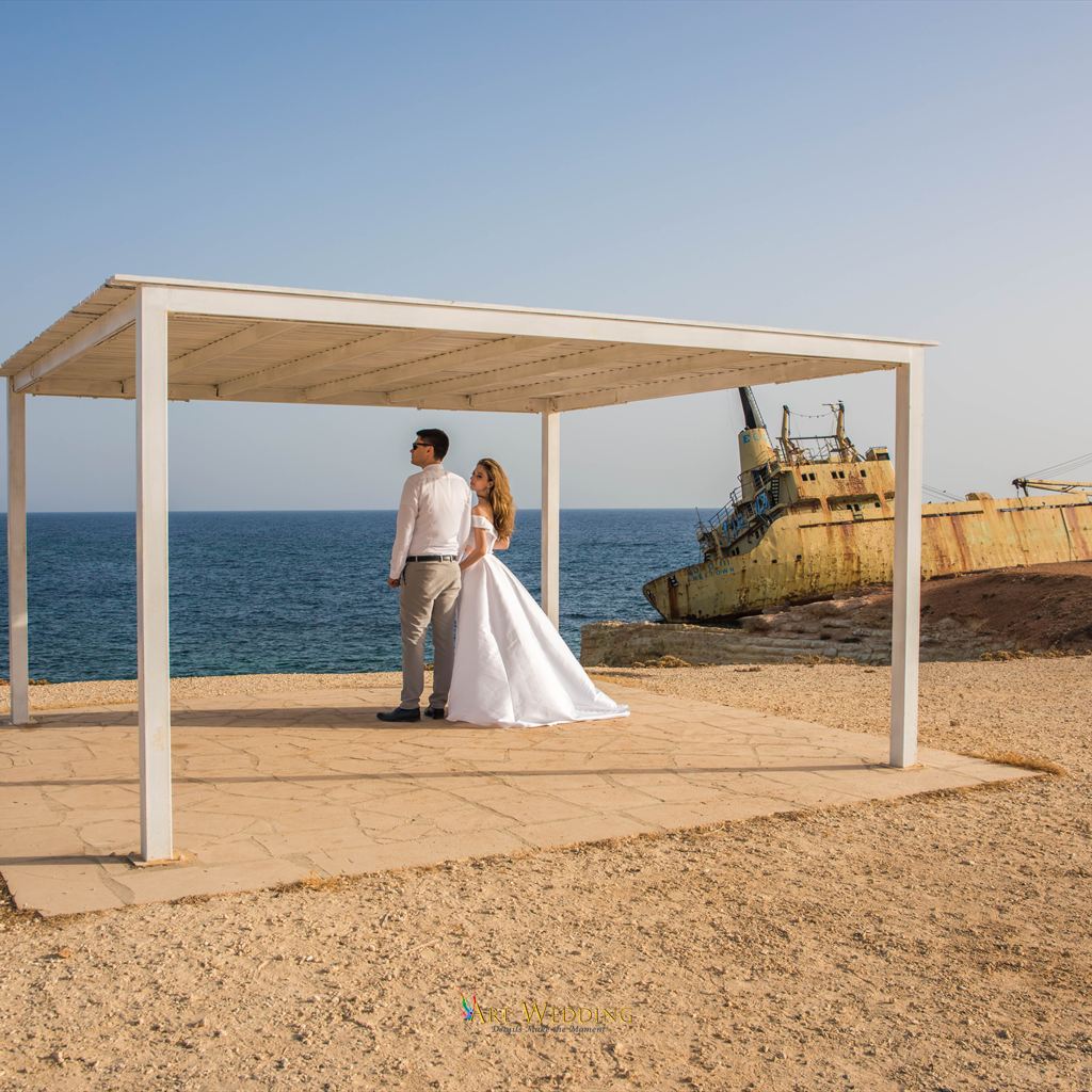 Wedding couple beneath a canopy beside the shipwreck