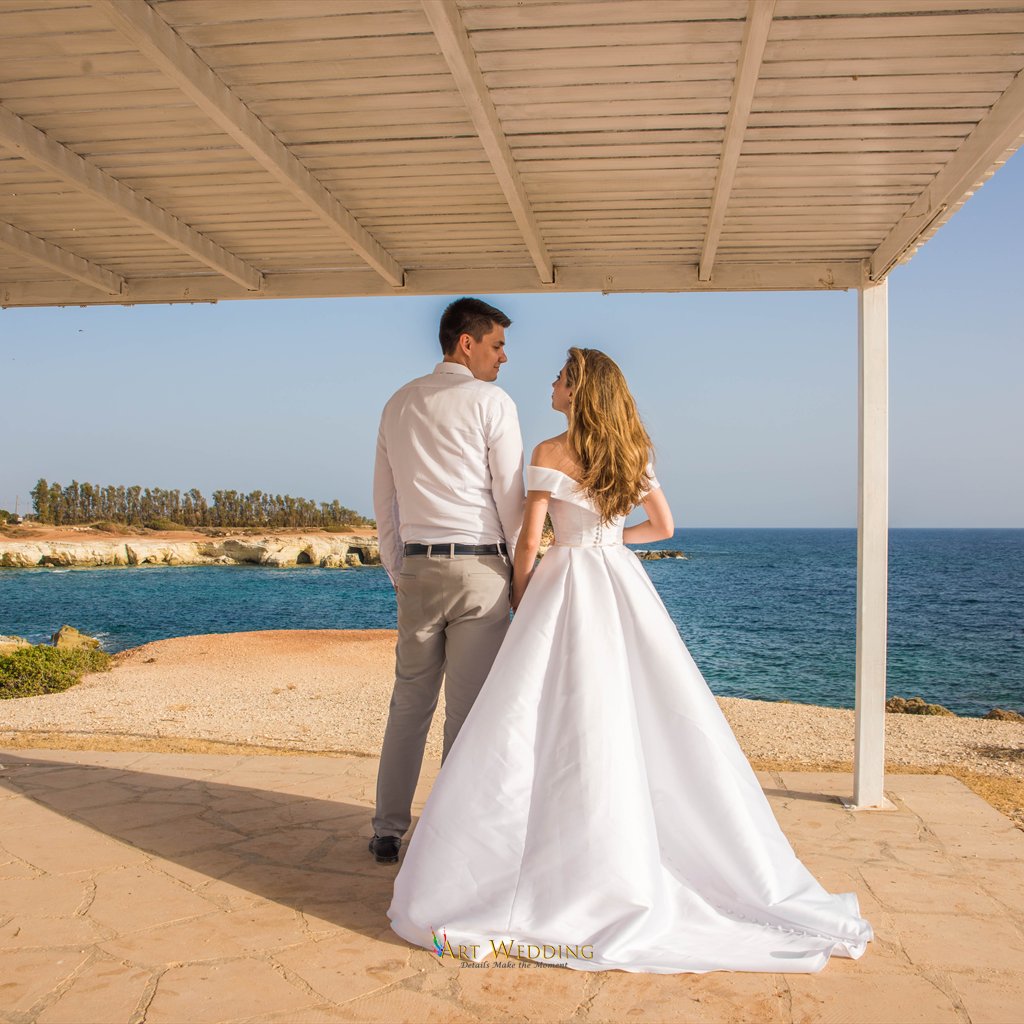 Newlyweds look at each other beneath the white canopy