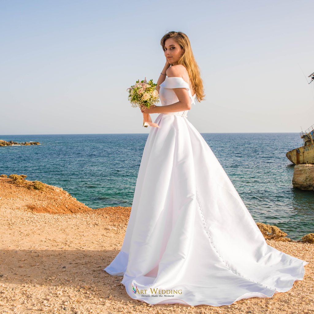 Bride with a bouquet overlooking the sea at the Red Cliffs